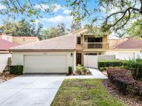 Charming home featuring a two-car garage, tile roof, balcony, and well-maintained landscaping at 1010 W Pebble Beach Cir, Winter Springs, FL 32708