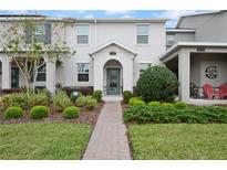 Charming townhome featuring lush landscaping, brick walkway and a welcoming front entrance at 12180 Sonnet Ave, Orlando, FL 32832