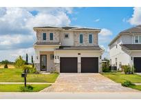 Beautiful two-story home featuring a stone facade and a two-car garage with brick paved driveway at 15750 Vetta Dr, Montverde, FL 34756