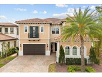 Stunning two-story home featuring a tile roof, balcony, arched windows, and a lush, landscaped yard with a palm tree at 3144 Players View Cir, Longwood, FL 32779
