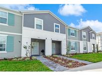 Charming townhome with modern gray siding, white trim, and inviting, well-maintained landscaping at 3966 Lana Ave, Davenport, FL 33897
