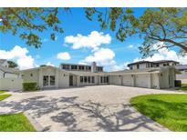 Expansive front yard with a stunning modern home featuring a three-car garage and beautiful landscaping at 49 Interlaken Rd, Orlando, FL 32804