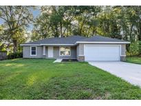 Charming single-story home with a well-manicured lawn and attached two car garage at 57 Pine Trace Crse, Ocala, FL 34472