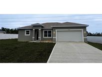 A single-story home featuring a two-car garage and well-manicured front lawn, showcasing its curb appeal at 6345 Sw 155Th Pl, Ocala, FL 34473