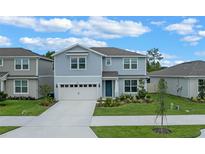 Charming two-story home boasts a well-manicured lawn and attached two car garage at 9763 Brown Burrow St, Orlando, FL 32829