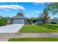 Charming single-story home featuring a well-manicured lawn and a two-car garage at 610 Palomas Ave, Ocoee, FL 34761