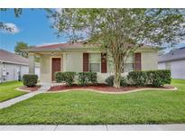 Charming single-story home with well-manicured lawn, mature tree, and inviting curb appeal at 14717 Royal Poinciana Dr, Orlando, FL 32828