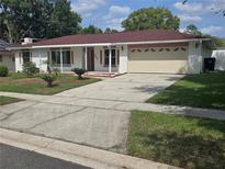 Charming single-story home with a red roof, attached garage and manicured front yard at 217 Longleaf Ct, Orlando, FL 32835