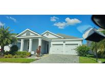 Beautiful single-story home featuring a two-car garage, manicured landscaping, and a gray brick driveway at 3043 Beaver Creek Dr, Kissimmee, FL 34746