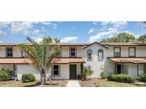 Charming condo featuring a well-manicured lawn, dark green front door and a healthy palm tree at 4060 E Maryland Pl, Casselberry, FL 32707
