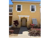 Inviting yellow home featuring white shutters and manicured landscaping creates a welcoming curb appeal at 1119 Park Ridge Cir, Kissimmee, FL 34746