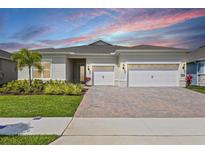 Charming single-story home with a three-car garage, paver driveway, and beautifully landscaped front yard at 13133 Sunny Retreat Ln, Winter Garden, FL 34787