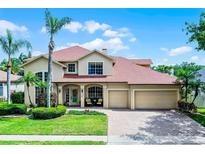 Beautiful two-story home with a well-maintained lawn, three-car garage, and inviting front porch at 3033 Zaharias Dr, Orlando, FL 32837