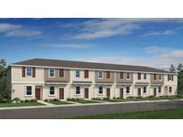 New townhouse property showcasing a contemporary design with a well-maintained lawn and inviting curb appeal at 3166 Skyline Loop, Kissimmee, FL 34758