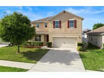 Two-story home featuring a two-car garage, well-manicured lawn, and charming red shutters at 3666 Maidencain St, Clermont, FL 34714