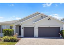 Charming home featuring a three-car garage, landscaped yard, and neutral paint scheme at 691 Blue Citrus Ln, Minneola, FL 34715