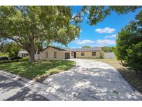 Charming single-story home features a circular driveway, lush landscaping, and mature trees for added curb appeal at 725 Laurel Way, Casselberry, FL 32707
