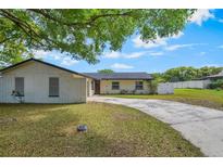 Charming single-story home featuring a long driveway and a well-maintained front yard with mature trees at 725 Laurel Way, Casselberry, FL 32707