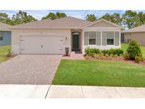 Charming single-story home boasts lush green lawn, brick driveway, and neutral exterior paint at 1511 Lyonsdale Ln, Sanford, FL 32771