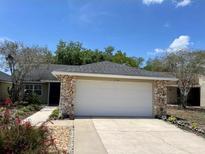 Charming single-story home with a two-car garage, stone accents, and a well-maintained front yard at 1034 Weathered Wood Cir, Winter Springs, FL 32708