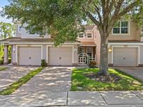 Charming townhome with attached garages and well-maintained landscaping showcasing its inviting curb appeal at 8316 Quimby Cir, Davenport, FL 33896
