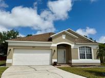 Charming single-story home with a well-maintained lawn and a two-car garage at 12101 Kendra Ct, Orlando, FL 32824