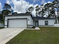 Charming one-story home featuring a 2-car garage, well-maintained lawn, and modern exterior finishes at 1476 11Th Ave, Deland, FL 32724