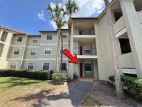 Exterior view of a three-story condo building with palm trees and a landscaped yard at 3028 Parkway Blvd # 105, Kissimmee, FL 34747