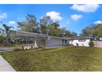 Charming single-story home with a carport and manicured lawn, complemented by a vibrant blue sky at 5144 Orange Ave, Winter Park, FL 32792
