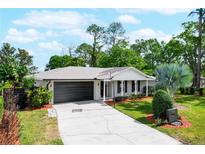 Charming single-story home featuring a well-manicured lawn, mature trees, and a two-car garage at 5301 Pineview Way, Apopka, FL 32703