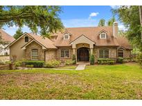 Charming brick home features a well-manicured lawn, mature trees, and a welcoming front entrance at 8800 Torey Pines Ter, Orlando, FL 32819
