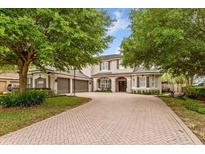 Charming home featuring a brick driveway, three-car garage, and manicured landscaping at 9880 Montclair Cir, Apopka, FL 32703
