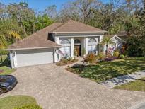 Well maintained single-Gathering home with a lush landscaped yard and a brick paved driveway leading to a two-car garage at 1137 Palm Cove Dr, Orlando, FL 32835