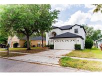 Charming two-story home with a well-manicured lawn and a spacious two-car garage at 2308 Holly Pine Cir, Orlando, FL 32820