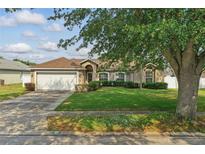 Charming single-story home featuring a well-manicured lawn and attached two-car garage at 2423 Auld Scot Blvd, Ocoee, FL 34761