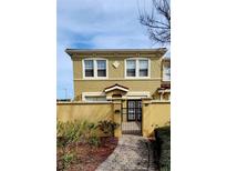 Charming two-story home with a gated courtyard, warm color scheme, and neatly landscaped greenery at 2834 Bella Vista Dr, Haines City, FL 33844
