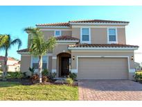 Charming two-story home featuring a red tile roof, two-car garage and well manicured lawn with tropical landscaping at 4420 Shiva Loop, Kissimmee, FL 34746