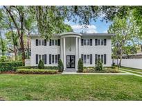 Stunning two-story home with elegant white columns, lush landscaping and black shutters at 613 Daniels Ave, Orlando, FL 32801