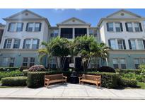 Well-maintained building featuring lush landscaping, benches, and a screened-in porch on the second level at 11446 Jasper Kay Terrace # 202, Windermere, FL 34786