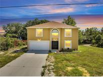 Charming two-story home boasting a large front yard, a two-car garage, and an arched entryway at 2004 Prescott Blvd, Deltona, FL 32738