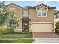 Two-story home featuring a two-car garage and neutral stucco exterior with well-maintained landscaping at 8828 Bengal Ct, Kissimmee, FL 34747