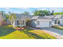 Charming single-story home with gray exterior, manicured lawn, and a two-car garage at 1052 Dees Dr, Oviedo, FL 32765