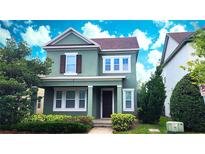 Charming two-story home featuring a covered porch, landscaped yard, and a beautifully painted exterior at 14154 Shocklach Dr, Winter Garden, FL 34787
