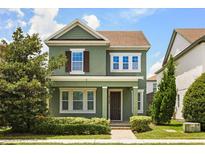 Charming two-story home with green exterior, brown shutters, manicured lawn, and inviting front porch at 14154 Shocklach Dr, Winter Garden, FL 34787