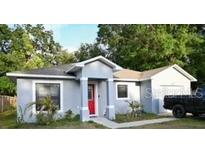 Charming single-story home featuring a freshly painted exterior, manicured lawn, and inviting red front door at 517 Walnut St, Auburndale, FL 33823