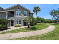 Inviting townhouse with a sidewalk, landscaping, and a playground nearby at 6506 Swissco Dr # 1317, Orlando, FL 32822