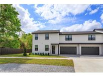 New construction townhome featuring a two-car garage, modern design, and landscaped front yard at 1340 Crystal Lake E Ave, Orlando, FL 32806