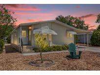 Charming single-story home featuring a well-maintained lawn, carport, and inviting front entrance at 220 Palmer Park Ln, Davenport, FL 33897