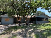 Exterior view of a single-story home with boarded windows and a screened-in porch at 4302 Seybold Ave, Orlando, FL 32808