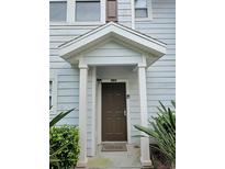 Inviting front door entrance with a peaked roof, light blue siding, and lush landscaping at 5354 Diplomat Ct # 105, Kissimmee, FL 34746